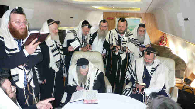 שמעון גליק יושב לצד הרב שטיינמן בתפילה במטוסו הפרט