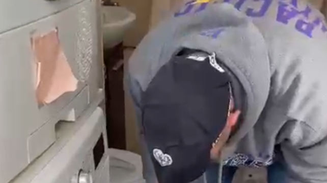 השוטר מבצע חיפוש במכונת הכביסה