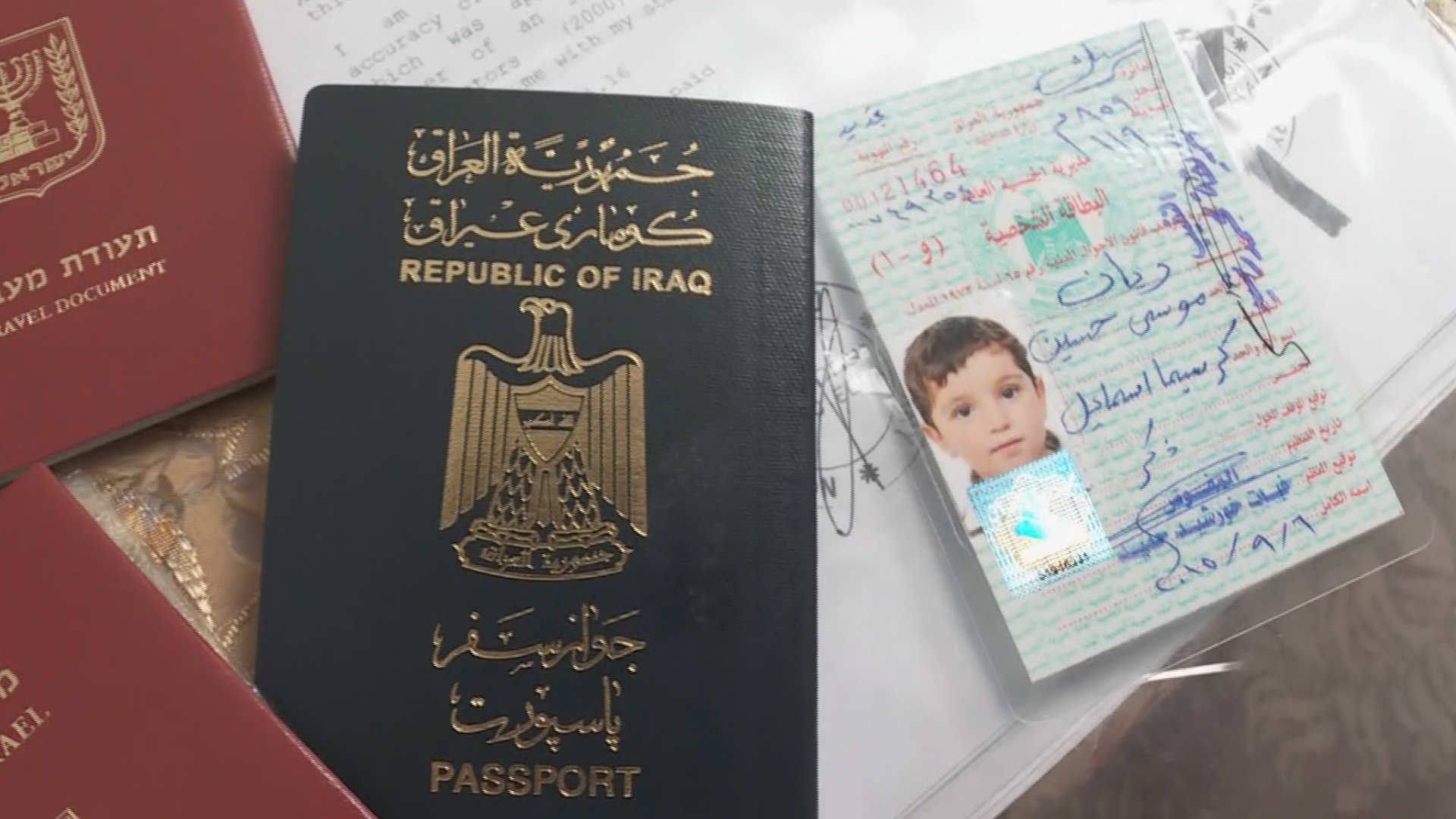 הדרכון העיראקי של אריאן לצד תעודות המעבר הישראליות