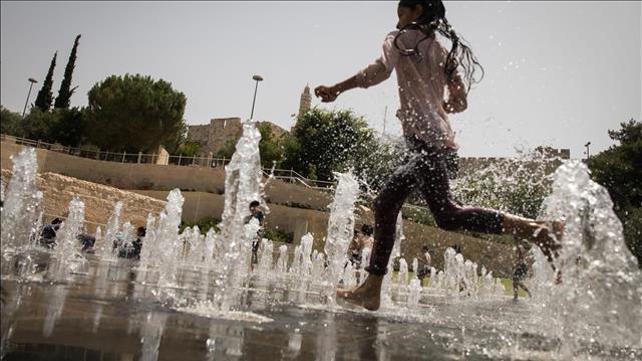 ילדה רצה במזרקה בשרב בירושלים, 2019