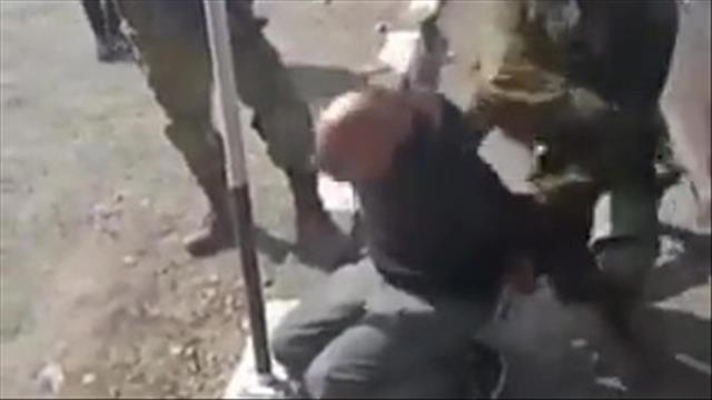 לוחם מכה עצור פלסטיני בחווארה