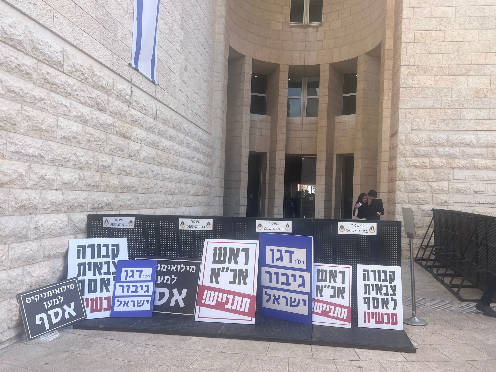 שלטי תמיכה במשפחת הנווט אסף דגן בפתח בית המשפט