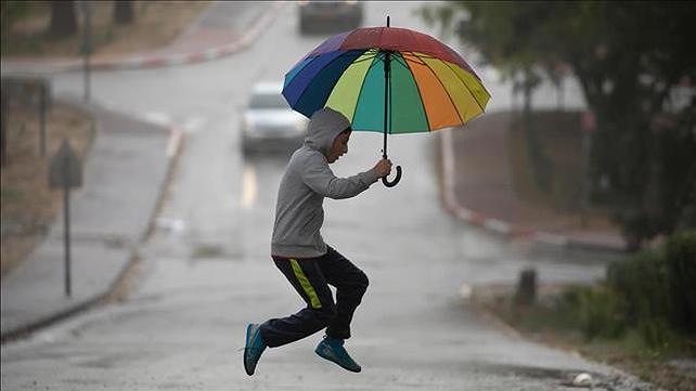 איש קופץ עם מטריה כי הוא אוהב את החורף. 25.3.21