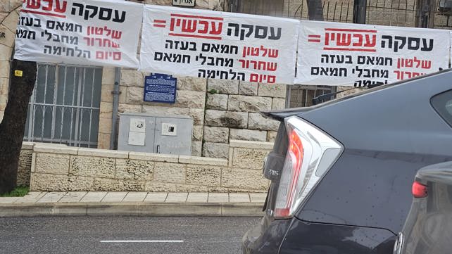 שלטים נגד העסקה סמוך למאהל משפחות החטופים בירושלים