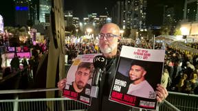 שי ונקרט, אביו של החטוף עומר ונקרט עם שלטי החטופים אביתר דוד וגיא גלבוע דלאל