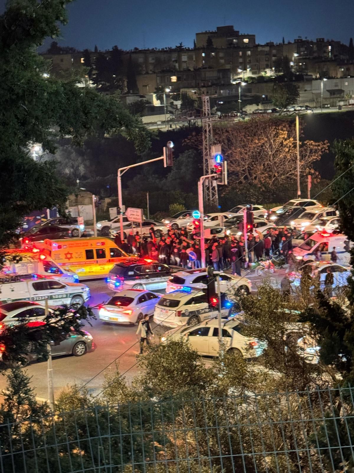 אנשים מתקהלים סביב אמבולנס לאחר אירוע ירי בנוף בגליל