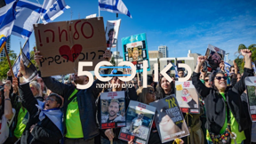 ישראלים צופים בשחרורם של סשה, יאיר ושגיא מהשבי