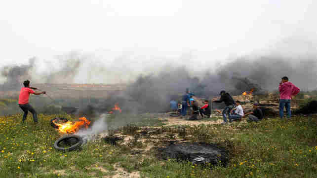 מפגינים פלסטינים על גדר המערכת ברצועת עזה