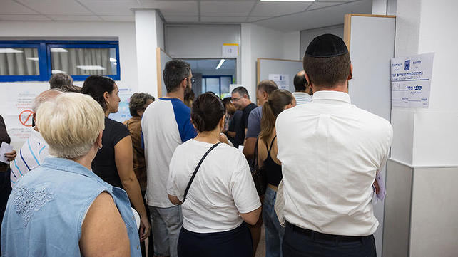 אנשים ממתינים בתור להצביע בקלפי