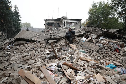 אדם מעל הריסות מבנה בז'פוריז'ה צילום: AP Photo/Kateryna Klochko