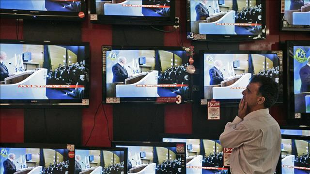 אדם צופה במסכי טלוויזיה בחנות מוצרי חשמל בירושלים