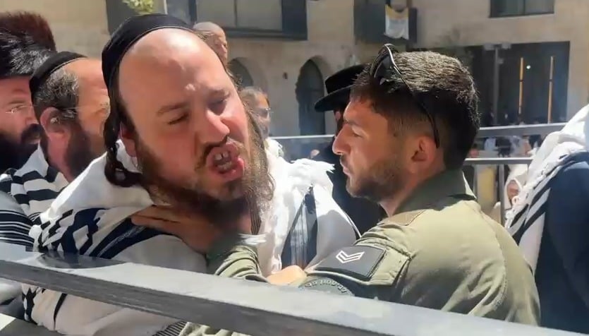 שוטר ומפגין בעימות ליד הפגנת חרדים סמוך לקפה "בסימטה" בירושלים