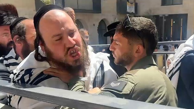 שוטר ומפגין בעימות ליד הפגנת חרדים סמוך לקפה "בסימטה" בירושלים