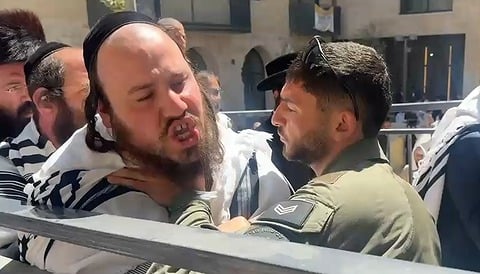 שוטר ומפגין בעימות ליד הפגנת חרדים סמוך לקפה 