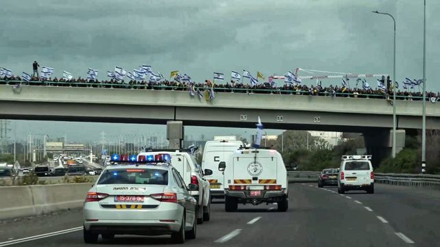 דגלי ישראל ודגלים צהובים על הגשר שמתחתיו עוברת השיירה באזור ראשון לציון