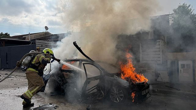 לוחם אש פועל לכיבוי שריפת הרכב שהתפוצץ