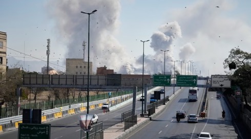 תמונות מלחמה: מכוניות נוסעות בכביש באחת מערי איראן, וברקע פטריות עשן