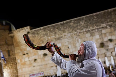 יהודי תוקע בשופר בעת הגעת מתפללים לתפילת סליחות בכותל המערבי, 9 באוקטובר 2024