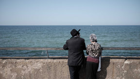 זוג חרדי עומד מול הים