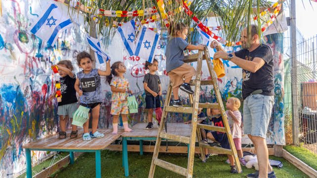ילדים בונים ומקשטים סוכה