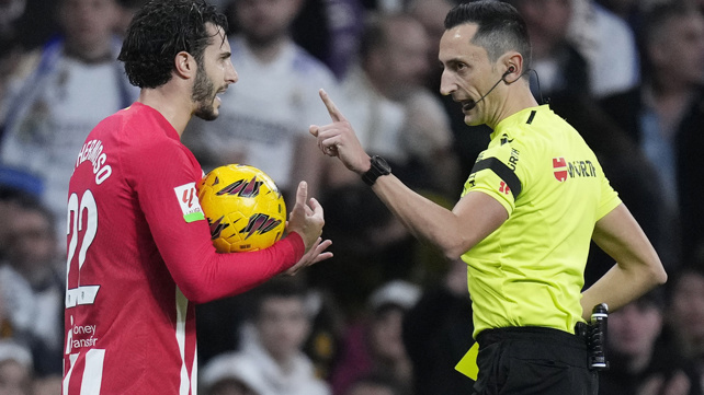 שופט כדורגל שולף כרטיס צהוב לשחקן אתלטיקו מדריד מריו הרמוסו