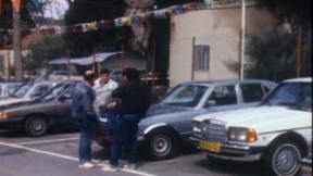 שלושה גברים במגרש מכוניות. 29.3.1988