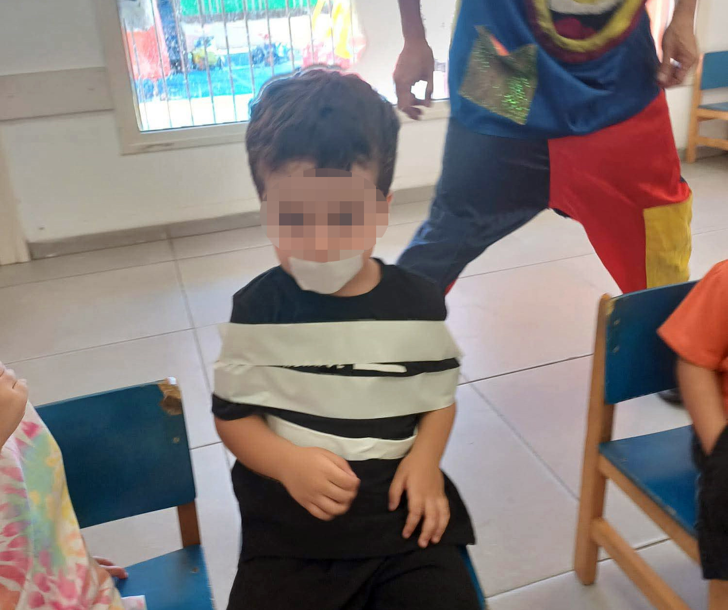 ילד שנקשר לכיסא בנייר דבק במעון ילדים