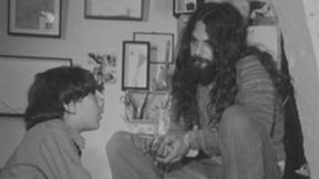 גבר בעל שיער ארוך יושב לצד ילד 1.1.1976