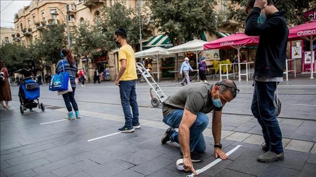 מוכר בחנות רחוב מדביק סימונים של שמירת מרחק 08.10.20